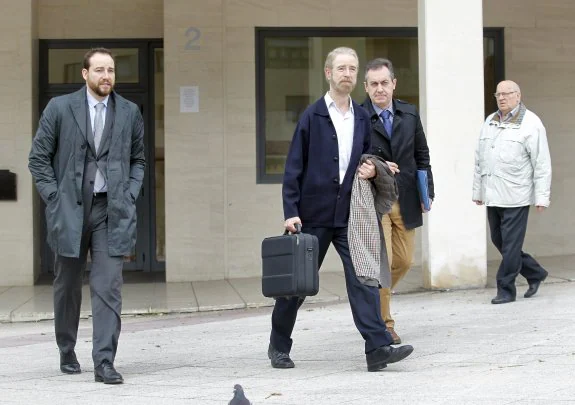 El neurólogo Alfredo Robles Bayón, en el centro, acompañado por el fiscal (izquierda) y el secretario judicial (derecha), abandonando el domicilio de Fernández Villa, tras realizar la prueba el pasado 11 de noviembre. 
