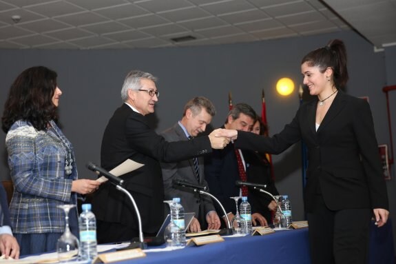 El rector felicita a una alumna entre Cristina Valdés y Daniel Ponte. 