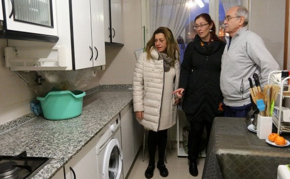 Rosa Espiño y Estefanía Puente, con el vecino Ángel Alonso, que les muestra a ambas los desperfectos bajo su caldera. 