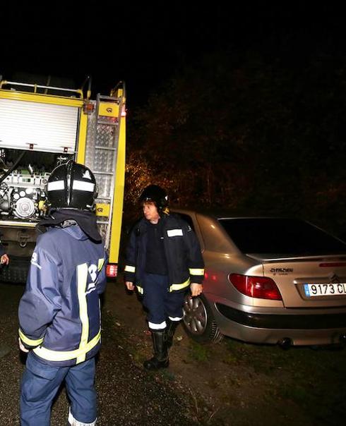 Bomberos, junto al coche del desaparecido. 