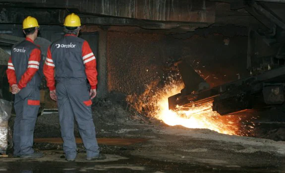 Dos trabajadores de ArcelorMittal, en la factoría gijonesa de la multinacional. 
