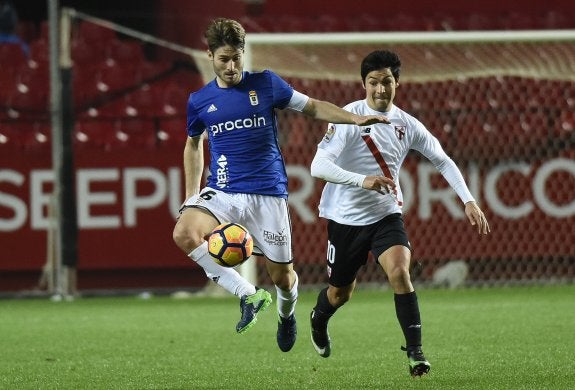 El capitán del Real Oviedo, Jon Erice, controla un balón en presencia del sevillista Borja Lasso.