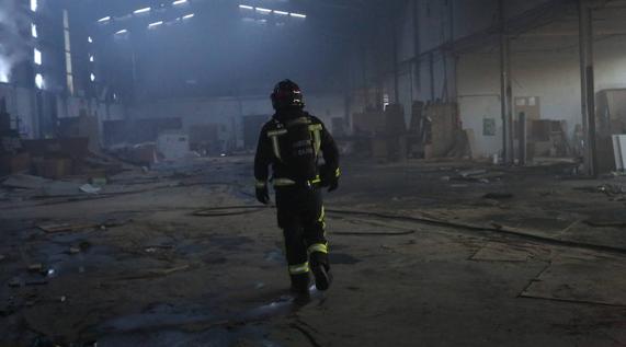 Un bombero, en el interior de la nave incendiada. 