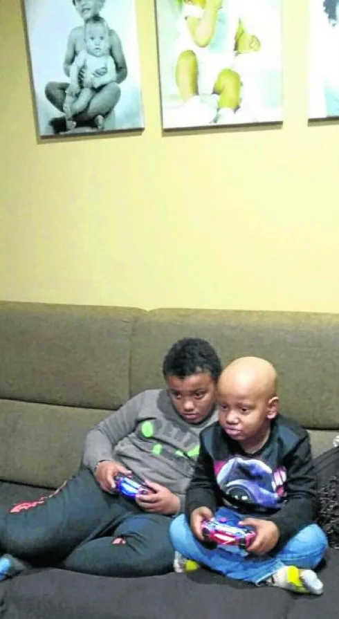 Samuel y Aarón, ya en su casa, juegan con su consola de videojuegos tras el regreso del pequeño al hogar después del trasplante. 
