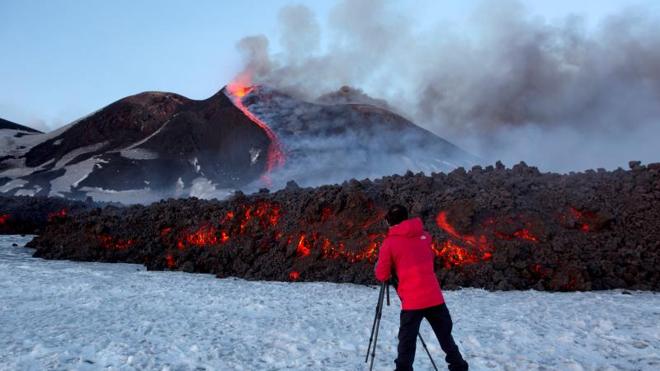 Un turista frente al volcán Etna.