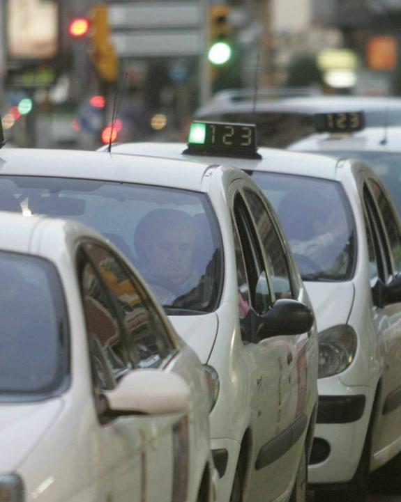 Taxistas en una parada en la calle Palacio Valdés. 