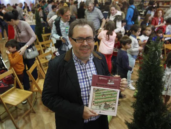 Neto García con el libro 'El vino de Cangas' en la feria del libro de Trascorrales . 