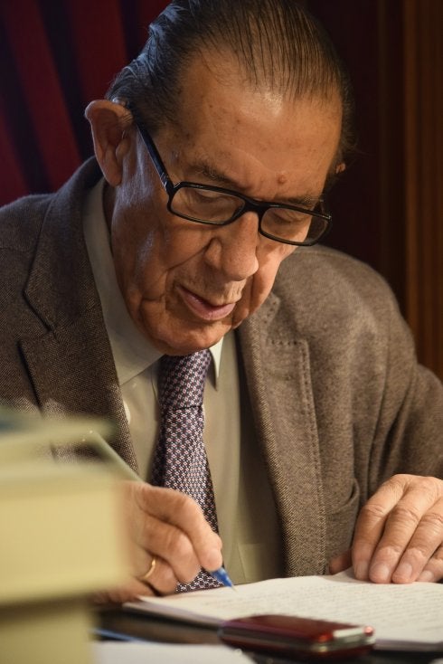 El economista escribre unos apuntes en un folio. 