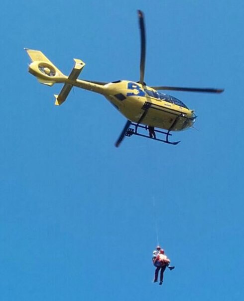 El helicóptero, durante la maniobra de rescate con el herido. 