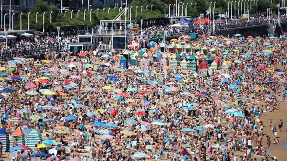 Gente en la playa de Gijón en pleno verano.