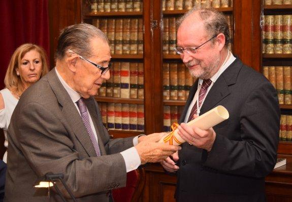 Leopoldo Tolivar (derecha) recibe el título de académico de manos de Juan Velarde 