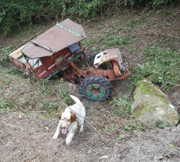 El tractor, volcado, junto a una de las piedras que cayeron a consecuencia del accidente. 