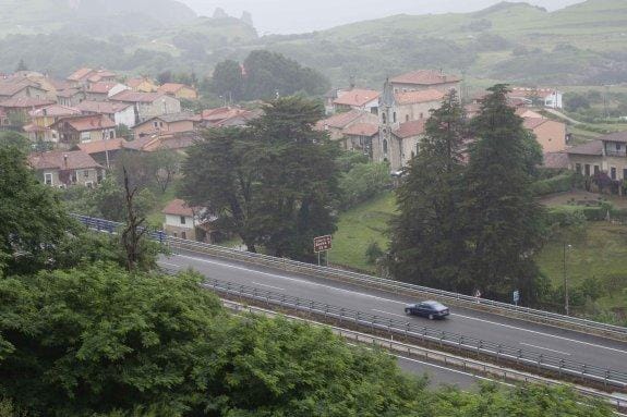 Un turismo transita por la Autovía del Cantábrico a su paso por la localidad de Buelna. 
