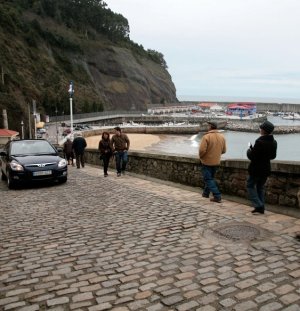 Los vehículos y transeúntes comparten espacio en la carretera que baja al puerto de Lastres. ::
ACEBAL