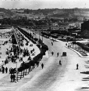 Paseantes por el Muro en los años 20. Al fondo, el Piles. A la derecha, arbolado y huertas donde hoy está el barrio de La Arena. ::                             EL COMERCIO