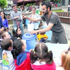 Un participante en el mercado enseña a los niños a reciclar. ::
ROMÁN