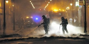 Los bomberos extinguen las llamas de una barricada en Mariano Pola, en las inmediaciones de la Semana Negra de Gijón.  ::                             JOAQUÍN BILBAO