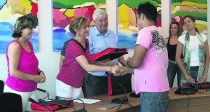 Esther Díaz entrega las llaves a uno de los nuevos inquilinos en presencia del alcalde de Gozón, Salvador Fernández. ::                             E. C.