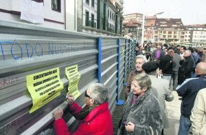 Vecinos de Candás escriben en el vallado mensajes de apoyo a la familia tras la manifestación. ::                             LUIS SEVILLA