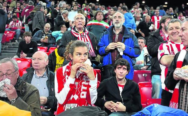 Varios aficionados comen un bocadillo en un partido de SanMamés.