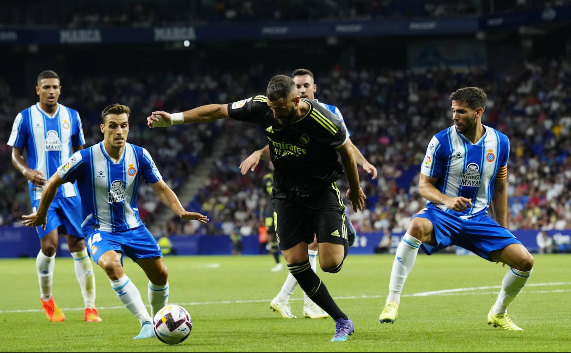 Benzemá trata de zafarse de la defensa blanquiazul en el pasado choque entre ambos equipos.