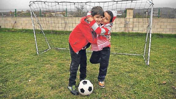 Gari Fernández se abraza a su hermano Telmo, de 5 años, ayer en el jardín de su casa de Villasana de Mena.