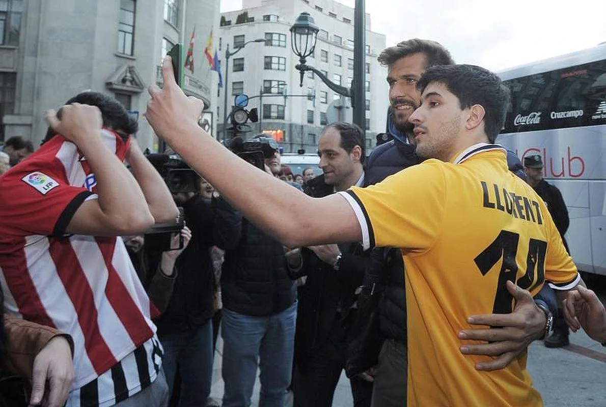 Fernando Llorente se fotografía con un aficionado junto al hotel.