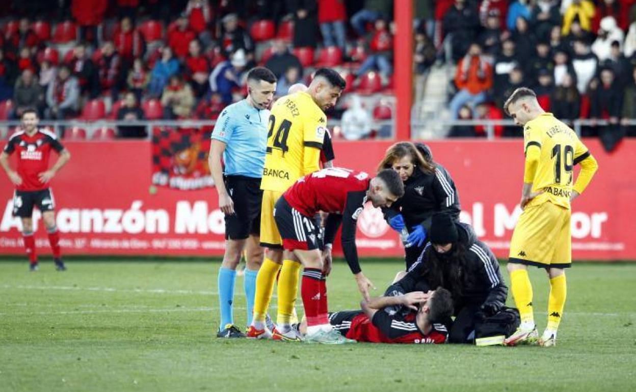 Los servicios médicos del club atienden al delantero tras sufrir el golpe en el costado izquierdo de la cara. 