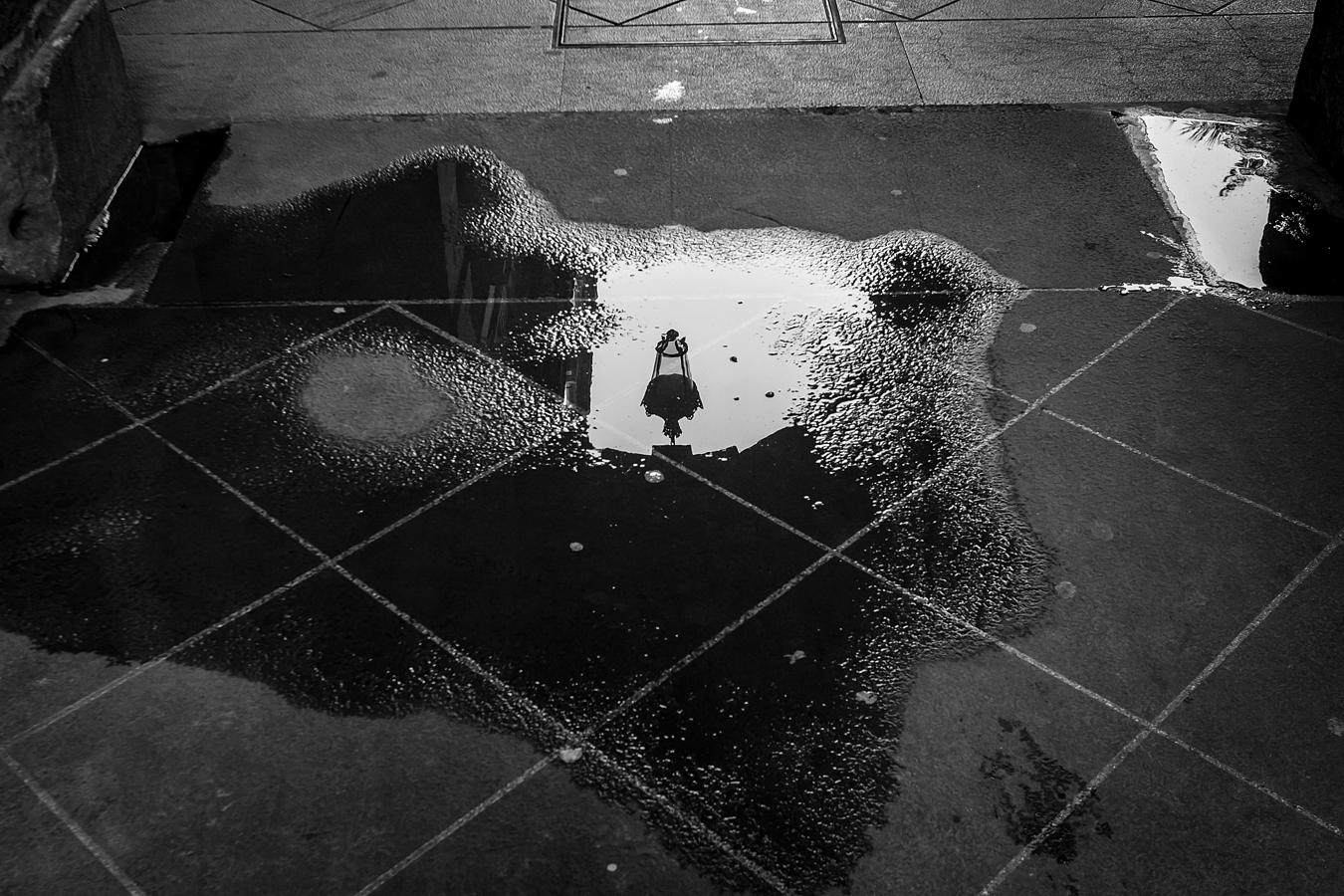 Los charcos también son 'espejos' en la Plaza Nueva.