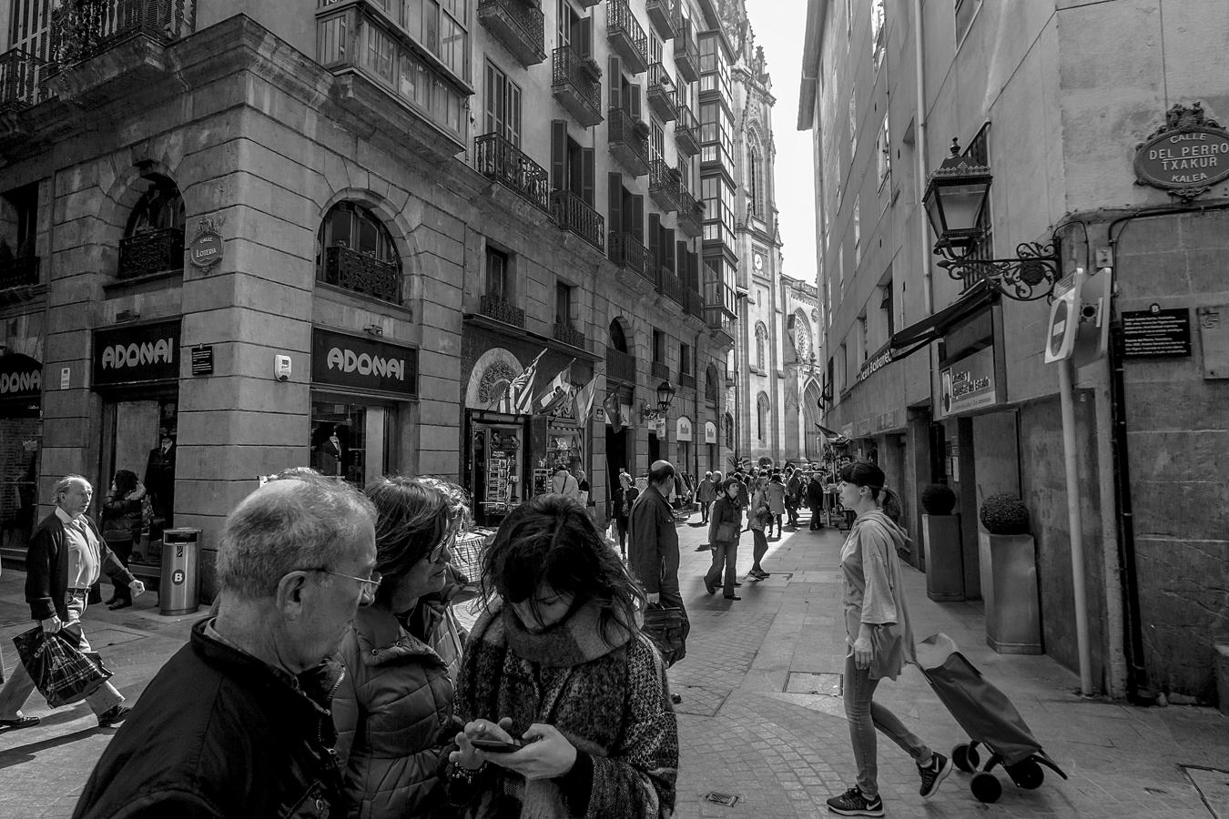 Bolsas de compras, móviles... a los transeúntes a veces se les acumula el trabajo.