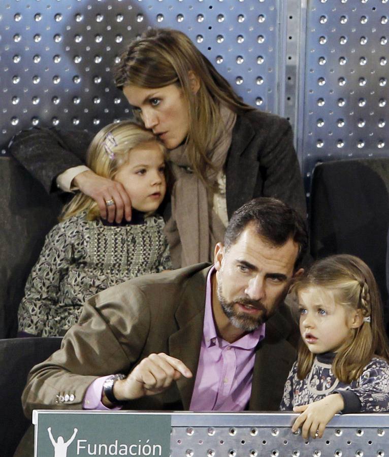 Felipe de Borbón habla con su hija Leonor mientras su esposa, Letizia, besa a la otra hija de los príncipes de Asturias, durante un partido benéfico de tenis.