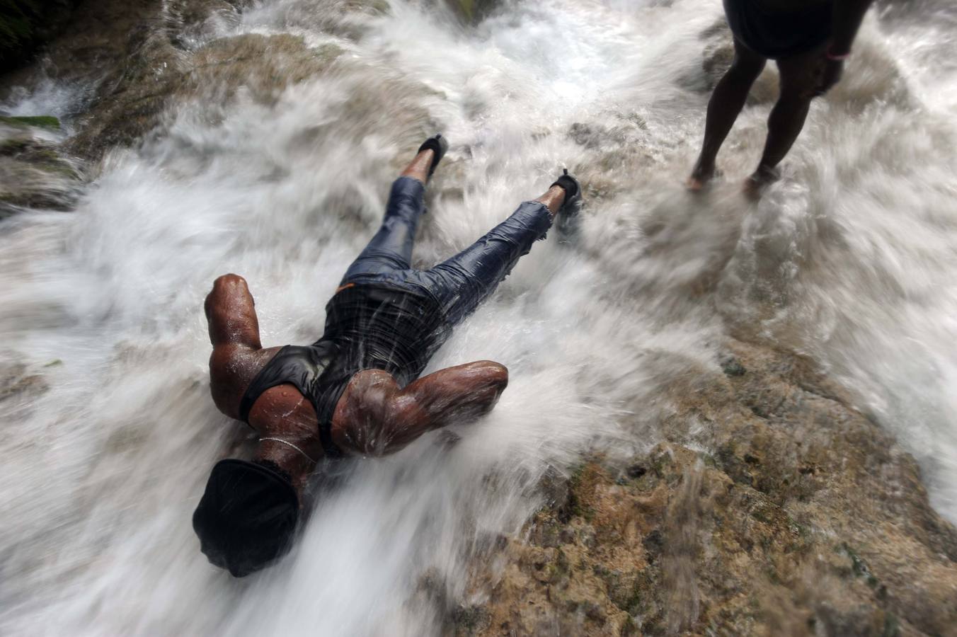 Los haitianos celebran el rito vudú en una cascada