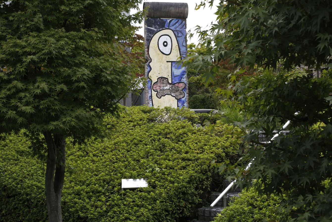 Árboles y setos rodean una parte del Muro de Berlín que se levanta en Yokohama, al sur de Tokio (Japón).