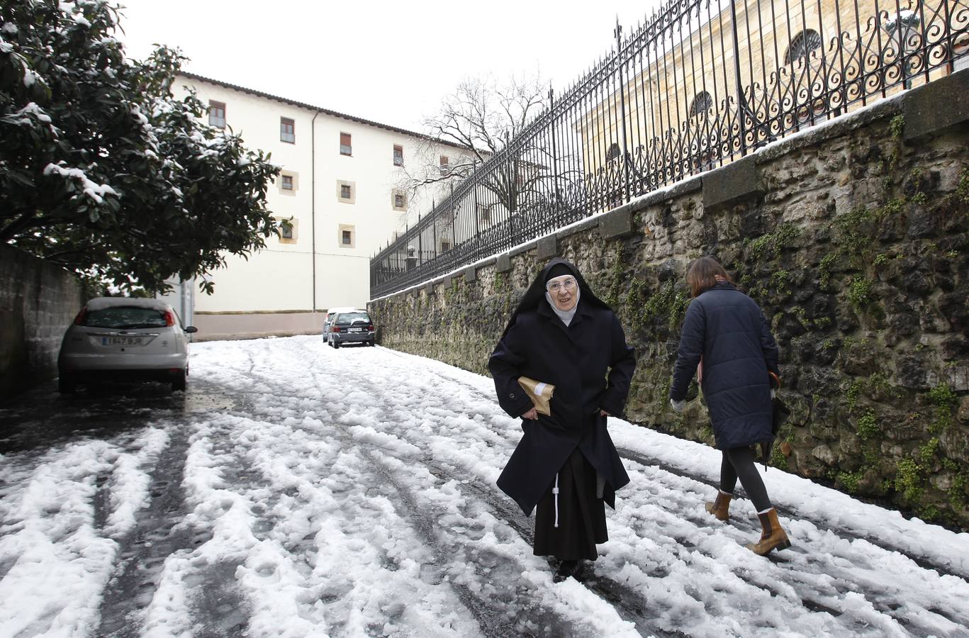 Religiosa intenta andar por la nieve en Gernika.. 