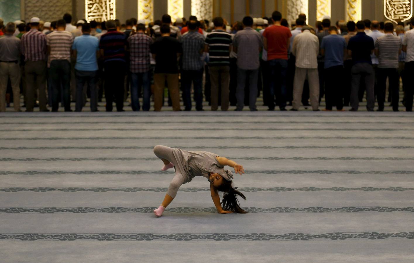 Una niña juega mientras los adoradores asisten las oraciones de la noche en la mezquita de Ahmet Hamdi Akseki en Ankara, Turquía