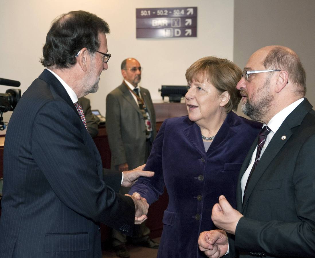 Mariano Rajoy da la mano a Angela Merkel
