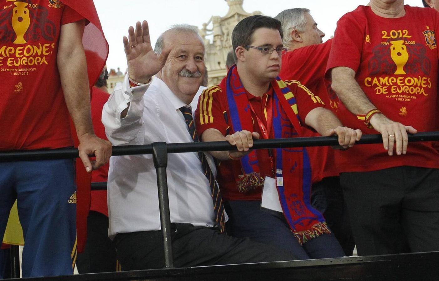 Vicente del Bosque, entrenador de la selección española de fútbol, acompañado de su hijo Álvaro, saluda desde el autobús que recorre las calles de Madrid para celebrar el título de campeones de la Eurocopa 2012.