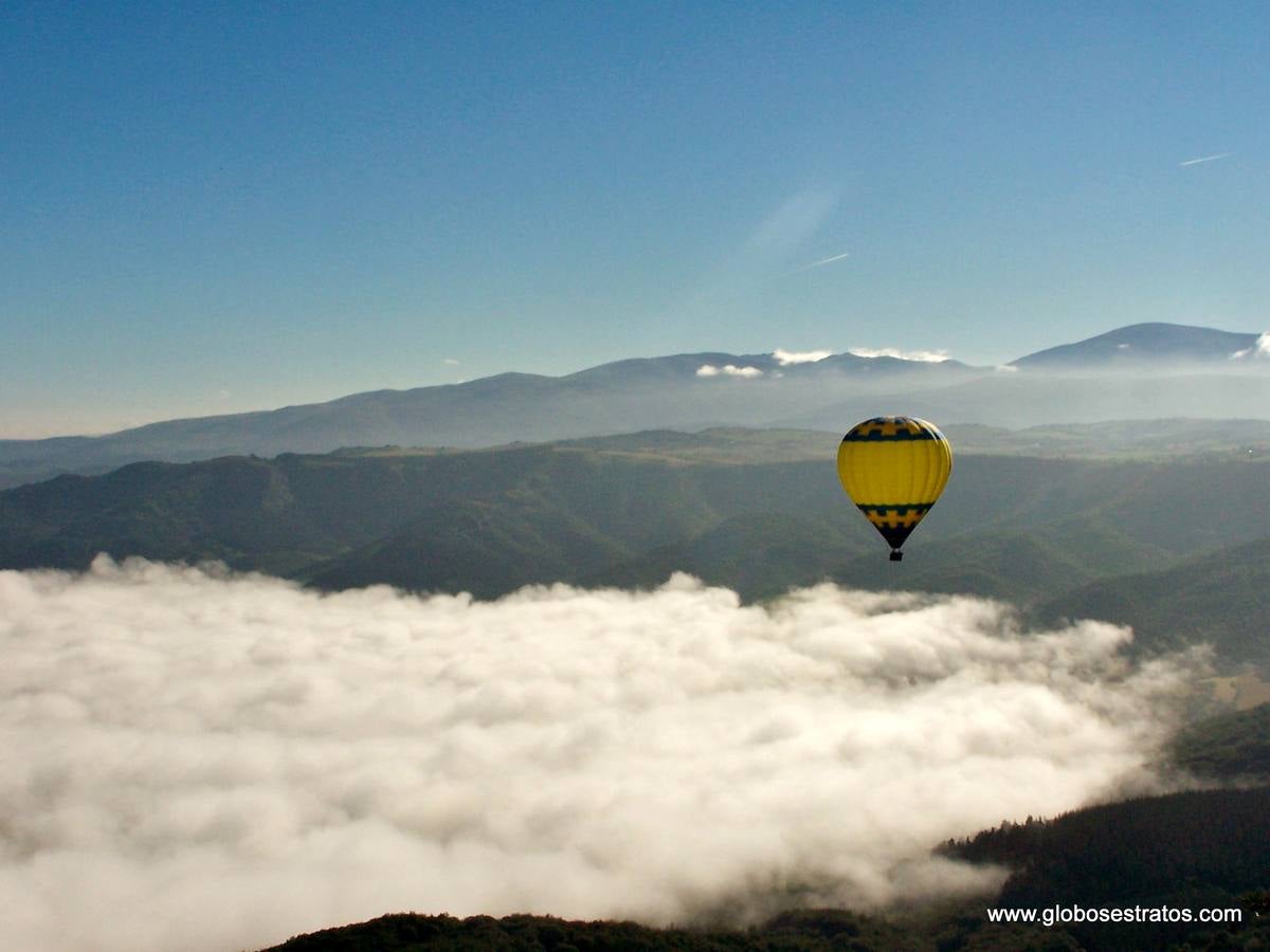 El globo cruza entre nubes.