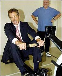 El exprimer ministro Tony Blair hace deporte en una máquina de remo.