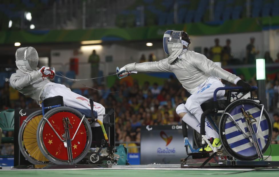 Vasileios Ntounis (derecha) de Grecia compite con Tian Jianquan de China en la esgrima en silla de ruedas .