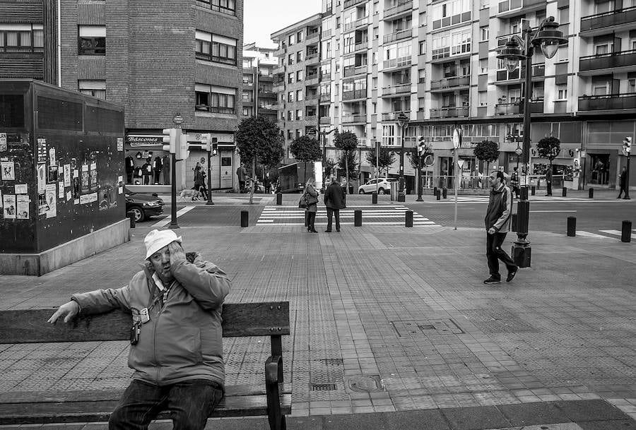Un hombre descansa en uno de los bancos de la calle Carmelo.