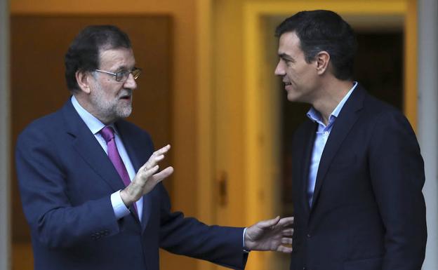 Rajoy y Sánchez charlan antes de iniciar su reunión.