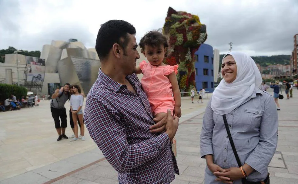 Bashira Hosaino observa a su hija, Asmahan salah Mahmoud, en brazos de su hermano Ahmed Hosaino. Viven junto al resto de la familia en Bilbao.