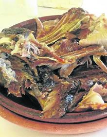 Imagen secundaria 2 - De arriba a abajo y de izquierda a derecha. Templo de la Asunción en Roa de Duero, del siglo XVI y estilo gótico-tardío. Barricas apiladas en la bodega Pérez Pascuas. Lechazo al horno de El Nazareno.