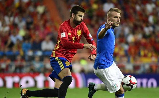 Gerard Piqué disputa un balón con Ciro Immobile,