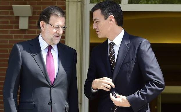 Rajoy (i) conversa con Pedro Sánchez. 