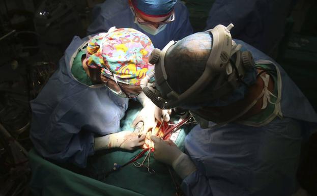 Tres cirujanos, en pleno trasplante.
