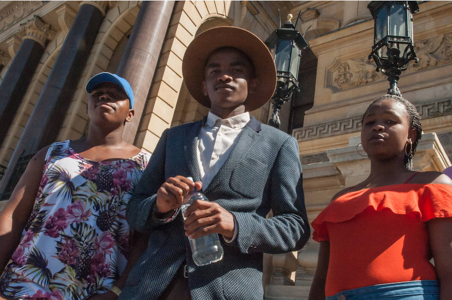 Jóvenes sudafricanos pasean a las puertas del Ayuntamiento de Ciudad del Cabo, donde Mandela dio su primer discurso tras 27 años de reclusión.