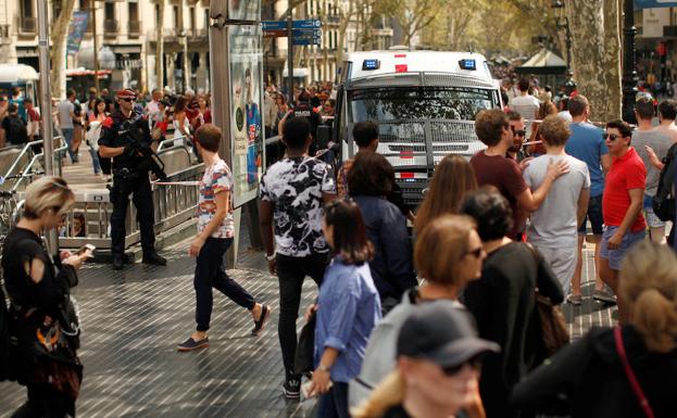 Imagen principal - Arriba, agentes de los Mossos patrullan las Ramblas de Barcelona. A la izquierda, un millar de tractores se concentraron ayer en Lleida. A la derecha, colocación de carteles a favor de referéndum. 