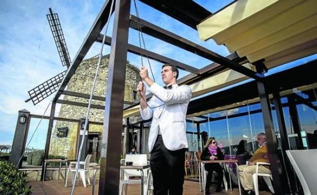 Un camarero del Cubita extiende los toldos de la terraza. 